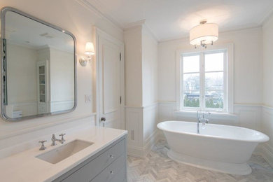 トロントにある広いトラディショナルスタイルのおしゃれな浴室 (グレーのキャビネット、白いタイル、磁器タイル、白い壁、大理石の床、アンダーカウンター洗面器、クオーツストーンの洗面台、白い床) の写真