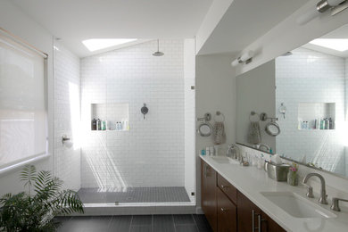 Modern inredning av ett litet en-suite badrum, med ett undermonterad handfat, släta luckor, skåp i mellenmörkt trä, bänkskiva i kvartsit, en öppen dusch, vit kakel, keramikplattor och klinkergolv i porslin
