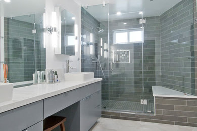 Large contemporary ensuite bathroom in Los Angeles with glass-front cabinets, grey cabinets, a corner shower, grey tiles, porcelain tiles, grey walls, cement flooring, a vessel sink, solid surface worktops, grey floors, a hinged door and white worktops.