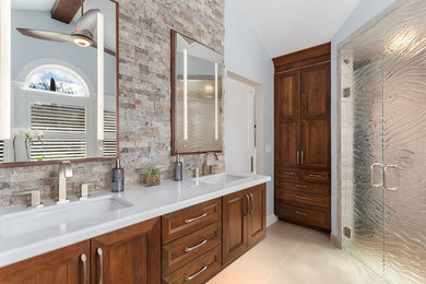 Example of a mid-sized trendy master porcelain tile porcelain tile and beige floor walk-in shower design in San Francisco with furniture-like cabinets, medium tone wood cabinets, gray walls, an undermount sink, a hinged shower door and white countertops