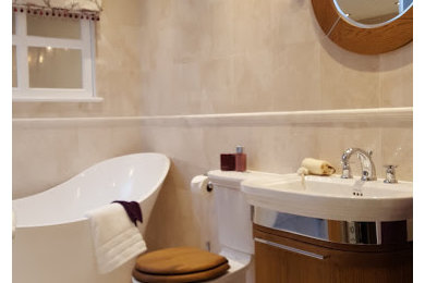 На фото: ванная комната с отдельно стоящей ванной, бежевыми стенами, подвесной раковиной и бежевым полом