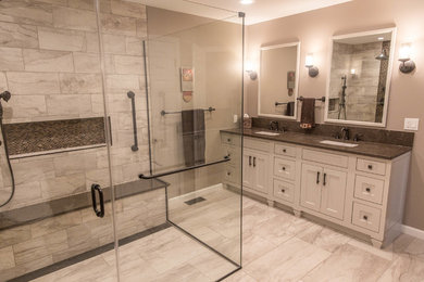 Example of a large transitional master porcelain tile walk-in shower design in Philadelphia with shaker cabinets, beige walls, an undermount sink, quartz countertops and a hinged shower door