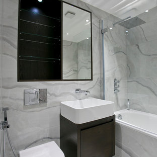 Example of a trendy gray tile bathroom design in London with a vessel sink, flat-panel cabinets, dark wood cabinets and a wall-mount toilet
