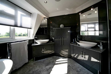 Design ideas for a contemporary family bathroom in Other with flat-panel cabinets, black cabinets, a freestanding bath, a walk-in shower, a wall mounted toilet, black tiles, porcelain tiles, black walls, ceramic flooring, a vessel sink, quartz worktops, grey floors, an open shower and grey worktops.