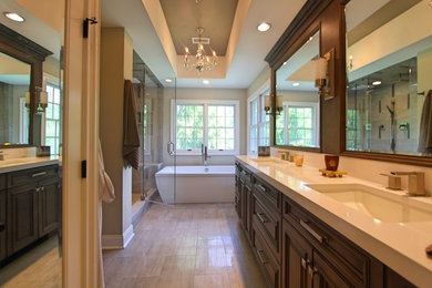 Large transitional master gray tile and porcelain tile porcelain tile and gray floor bathroom photo in New York with raised-panel cabinets, gray cabinets, a one-piece toilet, gray walls, an undermount sink, quartz countertops, a hinged shower door and white countertops