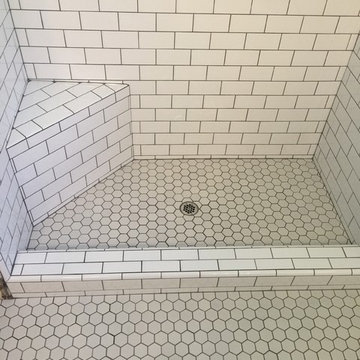 Subway tile shower with corner seat and 1"X1" hexagon floor.