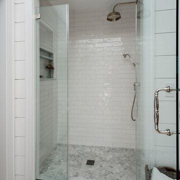 Subway tile shower with rain head, niche and frameless surround