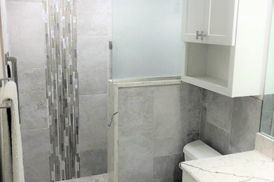 Bathroom - small modern master gray tile and porcelain tile porcelain tile, gray floor and single-sink bathroom idea in Miami with shaker cabinets, white cabinets, a one-piece toilet, gray walls, an undermount sink, quartzite countertops, white countertops, a niche and a built-in vanity