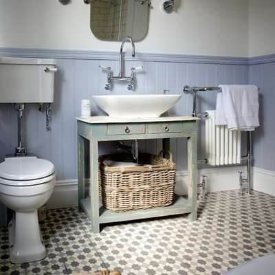 Example of a mid-sized cottage chic cement tile and gray tile mosaic tile floor bathroom design in Sussex with furniture-like cabinets, distressed cabinets, a two-piece toilet, multicolored walls and a vessel sink