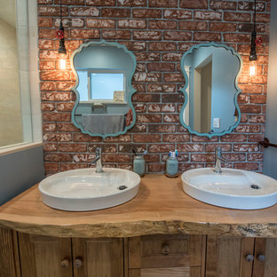 Mittelgroßes Shabby-Look Badezimmer En Suite mit verzierten Schränken, hellbraunen Holzschränken, Nasszelle, Wandtoilette mit Spülkasten, roten Fliesen, blauer Wandfarbe, Keramikboden, Aufsatzwaschbecken, Waschtisch aus Holz, beigem Boden, offener Dusche und brauner Waschtischplatte in Vancouver