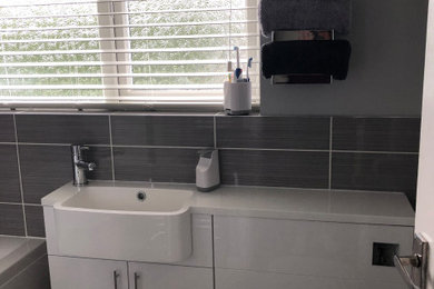 Diseño de cuarto de baño único moderno con bañera empotrada, lavabo encastrado, encimera de acrílico, ducha con puerta con bisagras y encimeras blancas