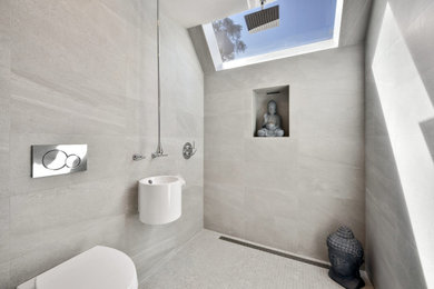 Example of a mid-sized zen gray tile and porcelain tile mosaic tile floor and vaulted ceiling doorless shower design in San Francisco with white cabinets, a wall-mount toilet, a niche and a floating vanity