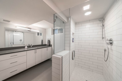 ポートランドにあるモダンスタイルのおしゃれな浴室 (白いキャビネット、コーナー設置型シャワー、白いタイル、白い壁、アンダーカウンター洗面器、グレーの床、開き戸のシャワー、グレーの洗面カウンター) の写真