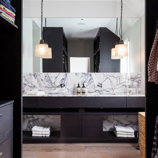 Foto de cuarto de baño principal, contemporáneo, con lavabo bajoencimera, armarios abiertos, puertas de armario de madera en tonos medios, encimera de mármol y suelo de madera clara