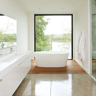 Idee per una stanza da bagno padronale moderna di medie dimensioni con lavabo rettangolare, ante lisce, ante bianche, vasca freestanding, doccia alcova, piastrelle bianche, pavimento in cemento e pareti bianche