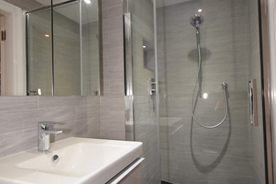 Cette photo montre une petite salle de bain tendance avec un placard à porte plane, WC suspendus, un sol en carrelage de céramique, un lavabo suspendu et une cabine de douche à porte battante.