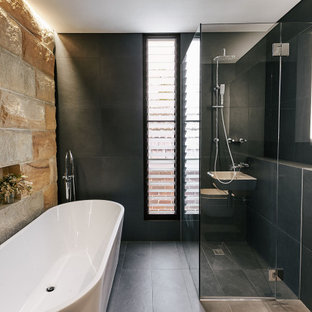 Design ideas for a mid-sized contemporary master bathroom in Sydney with a freestanding tub, a corner shower, a wall-mount toilet, gray tile, a wall-mount sink, grey floor and a shower curtain.