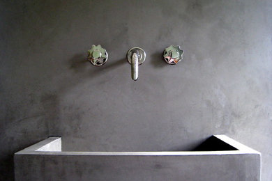 Imagen de cuarto de baño actual con lavabo suspendido, baldosas y/o azulejos grises y paredes grises