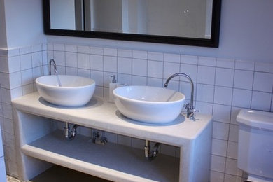 Bild på ett rustikt badrum, med ett fristående handfat, vit kakel, keramikplattor, vita väggar och betonggolv