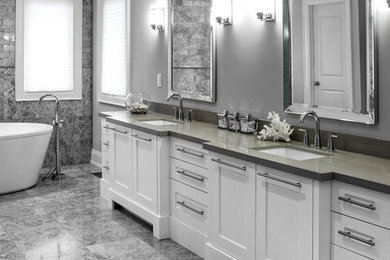 Exempel på ett stort klassiskt en-suite badrum, med skåp i shakerstil, vita skåp, ett fristående badkar, en toalettstol med hel cisternkåpa, grå kakel, stenkakel, grå väggar, marmorgolv, ett undermonterad handfat och bänkskiva i akrylsten