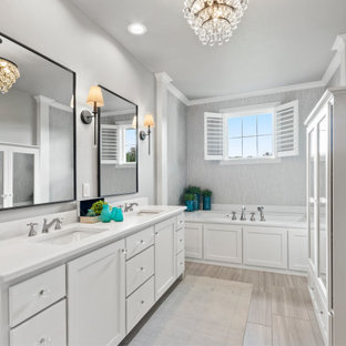 Inspiration for a large coastal master ceramic tile and gray floor bathroom remodel in Other with shaker cabinets, white cabinets, an undermount tub, gray walls, an undermount sink, quartz countertops and white countertops