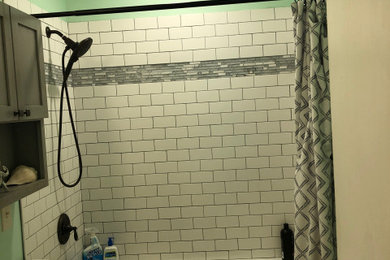 Пример оригинального дизайна: маленькая детская ванная комната в морском стиле с фасадами в стиле шейкер, серыми фасадами, ванной в нише, душем над ванной, раздельным унитазом, белой плиткой, керамогранитной плиткой, зелеными стенами, врезной раковиной, столешницей из искусственного кварца, шторкой для ванной, белой столешницей, тумбой под одну раковину и встроенной тумбой для на участке и в саду
