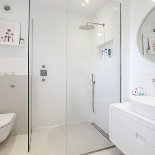 Photo of a small contemporary shower room bathroom in London with flat-panel cabinets, a wall mounted toilet, white tiles, white walls, a vessel sink, beige floors, an open shower, white worktops, white cabinets and a walk-in shower.