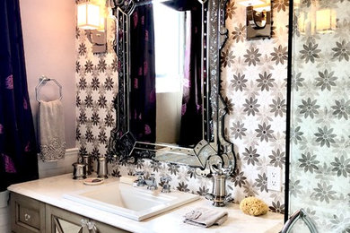 Mid-sized elegant 3/4 multicolored tile and marble tile marble floor and white floor corner shower photo in Philadelphia with furniture-like cabinets, light wood cabinets, a two-piece toilet, purple walls, a drop-in sink, marble countertops, a hinged shower door and white countertops