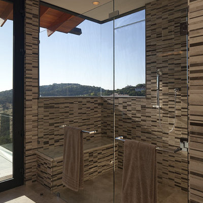 Large trendy master beige tile and stone tile porcelain tile bathroom photo in Austin with flat-panel cabinets, medium tone wood cabinets, brown walls, an undermount sink and solid surface countertops