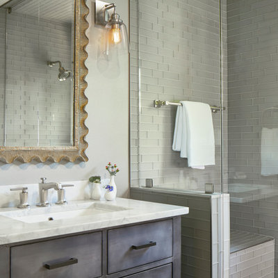 Example of a small farmhouse 3/4 gray tile and glass tile limestone floor and gray floor alcove shower design in Austin with flat-panel cabinets, gray cabinets, a one-piece toilet, gray walls, a drop-in sink, marble countertops, a hinged shower door and white countertops