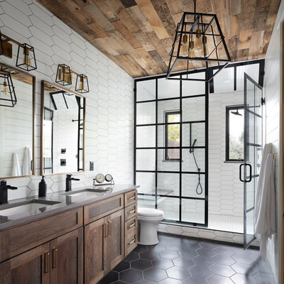 Inspiration for a transitional 3/4 white tile black floor alcove shower remodel in Denver with shaker cabinets, medium tone wood cabinets, an undermount sink, a hinged shower door and gray countertops