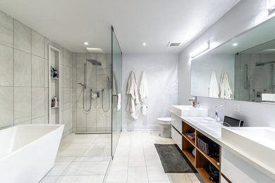 Example of a large trendy master blue tile and ceramic tile ceramic tile bathroom design in Toronto with flat-panel cabinets, white cabinets, a one-piece toilet, white walls, a vessel sink and quartz countertops