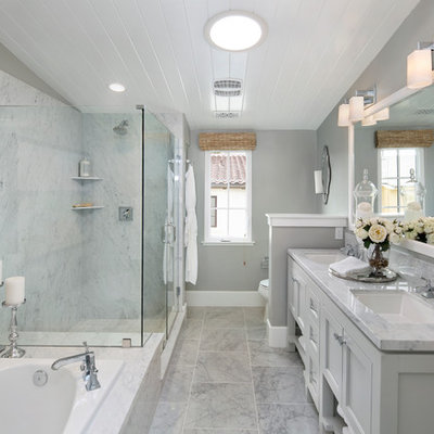 Example of a classic master gray tile drop-in bathtub design in San Francisco with recessed-panel cabinets, gray cabinets, gray walls, an undermount sink and a hinged shower door