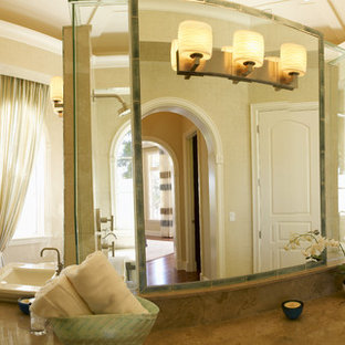 Großes Modernes Badezimmer En Suite mit flächenbündigen Schrankfronten, dunklen Holzschränken, Löwenfuß-Badewanne, Duschnische, grauen Fliesen, Spiegelfliesen, beiger Wandfarbe, Travertin, Aufsatzwaschbecken, Marmor-Waschbecken/Waschtisch, beigem Boden und Falttür-Duschabtrennung in Tampa