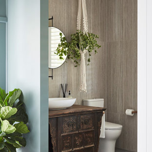 Design ideas for a mid-sized tropical 3/4 bathroom in Sydney with furniture-like cabinets, dark wood cabinets, a one-piece toilet, gray tile, porcelain tile, porcelain floors, a vessel sink, grey floor, grey walls, wood benchtops and brown benchtops.