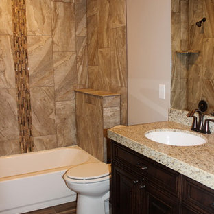 Large elegant kids' beige tile and ceramic tile medium tone wood floor bathroom photo in Salt Lake City with an undermount sink, raised-panel cabinets, dark wood cabinets, granite countertops, a two-piece toilet and beige walls