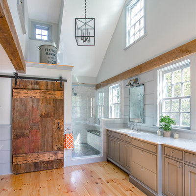 Example of a country master light wood floor claw-foot bathtub design in Boston with marble countertops