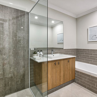 Inspiration for a mid-sized contemporary master bathroom in Perth with a corner shower, brown tile, white walls, beige floor, a hinged shower door, white benchtops, flat-panel cabinets, medium wood cabinets, a drop-in tub and a drop-in sink.