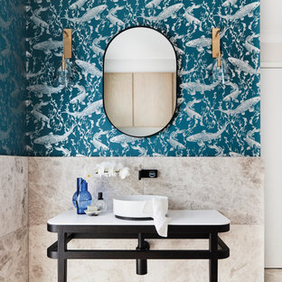 This is an example of a contemporary bathroom in Sydney with black cabinets, beige tile, blue walls, a vessel sink, beige floor, white benchtops, a single vanity, a freestanding vanity and wallpaper.