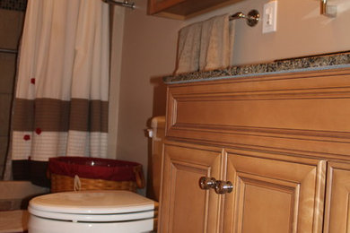 Diseño de cuarto de baño clásico pequeño con armarios con paneles lisos, puertas de armario de madera clara, encimera de granito, baldosas y/o azulejos de cerámica y suelo de baldosas de porcelana