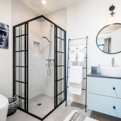 Bathroom - mid-sized industrial 3/4 gray floor and concrete floor bathroom idea in Other with flat-panel cabinets, blue cabinets, white walls, a vessel sink, gray countertops, a two-piece toilet and soapstone countertops