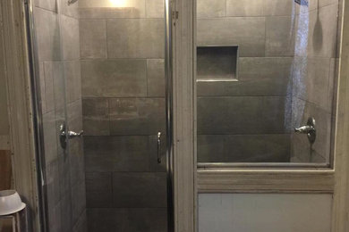Modelo de cuarto de baño actual de tamaño medio con ducha empotrada, baldosas y/o azulejos de cemento, paredes beige, suelo de baldosas tipo guijarro y suelo multicolor
