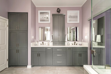 Example of a mid-sized trendy master porcelain tile porcelain tile and multicolored floor bathroom design in Austin with shaker cabinets, gray cabinets, a one-piece toilet, an undermount sink, quartz countertops, a hinged shower door and white countertops
