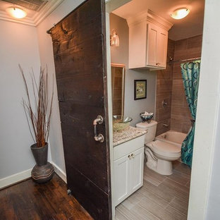 Esempio di una piccola stanza da bagno padronale american style con ante in stile shaker, ante bianche, vasca da incasso, vasca/doccia, WC a due pezzi, piastrelle grigie, piastrelle in ceramica, pareti grigie, pavimento con piastrelle in ceramica, lavabo a bacinella e top in granito