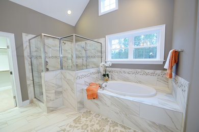 Imagen de cuarto de baño principal tradicional con puertas de armario grises, bañera empotrada, ducha empotrada, baldosas y/o azulejos blancos, paredes beige y encimera de granito