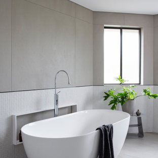 This is an example of a large contemporary bathroom in Sydney with a freestanding tub, multi-coloured tile, mosaic tile, porcelain floors and grey floor.
