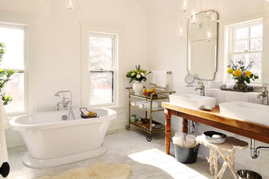 Imagen de cuarto de baño principal rural con bañera exenta, baldosas y/o azulejos blancos, paredes blancas y lavabo sobreencimera