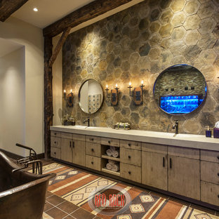 Immagine di un'ampia stanza da bagno padronale rustica con lavabo integrato, consolle stile comò, ante con finitura invecchiata, top in cemento, vasca freestanding, doccia doppia, WC monopezzo, piastrelle marroni, piastrelle di vetro, pareti beige e pavimento con piastrelle in ceramica