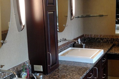 Ejemplo de cuarto de baño principal grande con puertas de armario de madera en tonos medios y encimera de granito