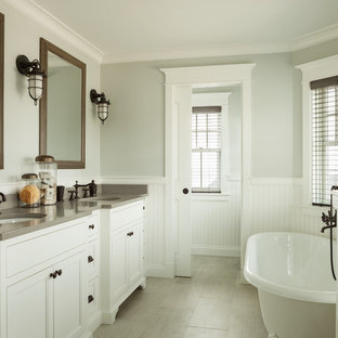 Foto på ett stort maritimt grå en-suite badrum, med ett undermonterad handfat, luckor med infälld panel, vita skåp, bänkskiva i kvarts, ett fristående badkar, grå kakel, porslinskakel och klinkergolv i keramik